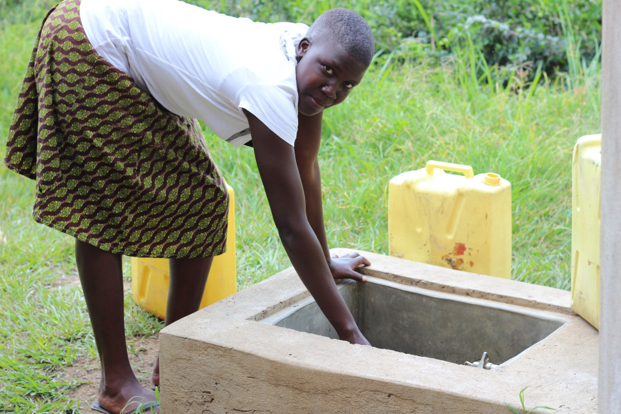 Student fetches water at the new tank behind her dorm 