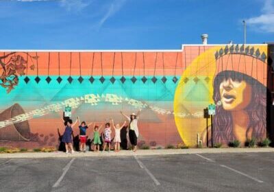 2022 U.S. Grassroots Accelerator Leader Nikila Badua and youth artists stand beside their completed mural