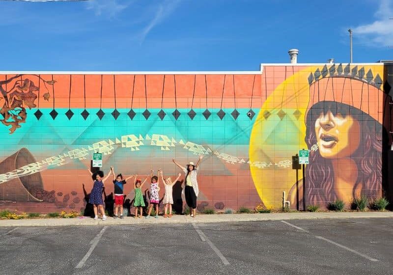 2022 U.S. Grassroots Accelerator Leader Nikila Badua and youth artists stand beside their completed mural