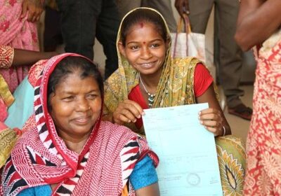 Basanti Dehuri, center, with the land title she received through a Women's Support Center (Photo: New York Times)