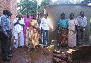 Charity (center in white) and Afuwa (behind Chairty) after installing a Rainwater Harvesting system in a WCFJC community